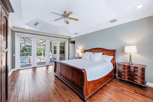 bedroom featuring ceiling fan, dark wood-type flooring, a tray ceiling, and access to outside