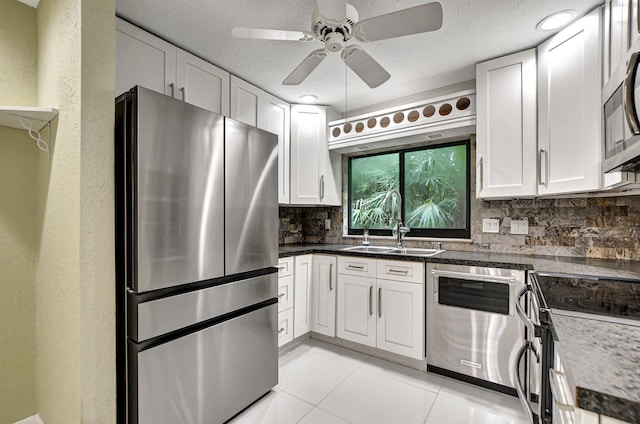 kitchen featuring white cabinets, stainless steel appliances, backsplash, and sink