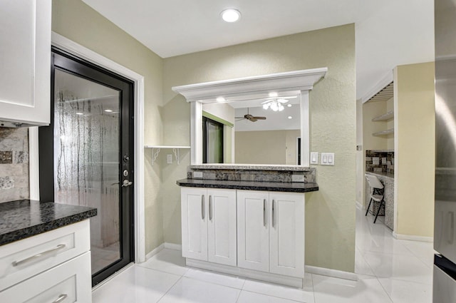 bathroom featuring tile patterned flooring, ceiling fan, an enclosed shower, decorative backsplash, and vanity