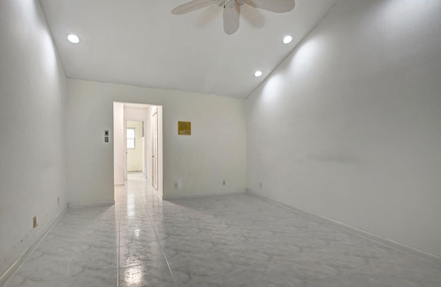 empty room with ceiling fan and vaulted ceiling