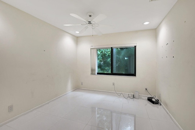 tiled spare room with ceiling fan