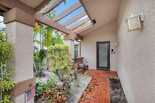 view of exterior entry with a pergola