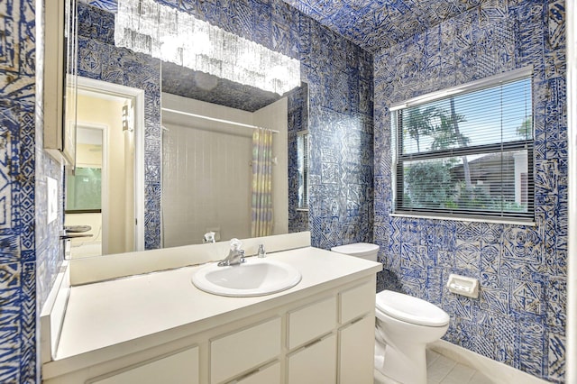 bathroom with vanity, tile patterned floors, tile walls, toilet, and a shower with shower curtain