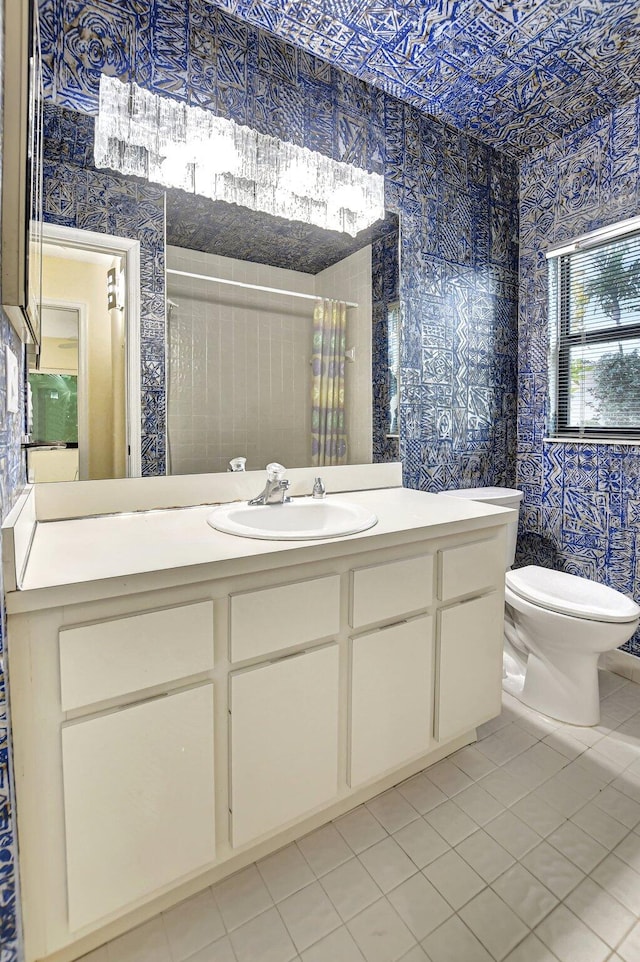 bathroom with tile patterned flooring, curtained shower, vanity, and toilet