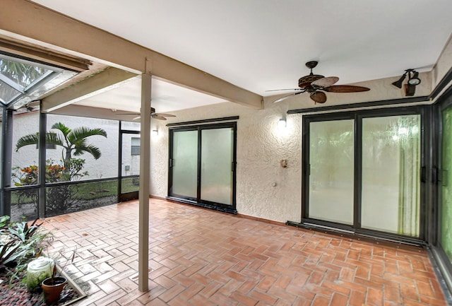 sunroom / solarium featuring ceiling fan and beam ceiling