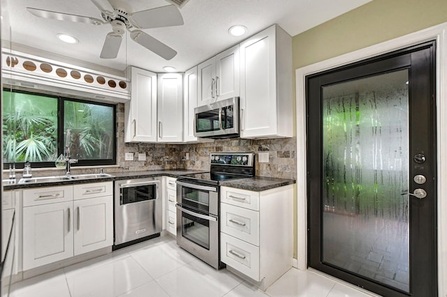 kitchen with stainless steel appliances, white cabinets, tasteful backsplash, and light tile patterned floors