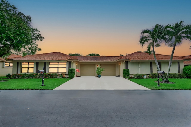 view of front facade with a garage and a lawn