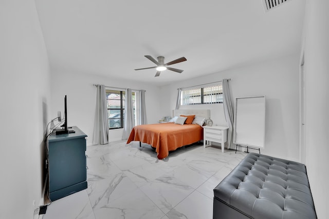 bedroom with ceiling fan and a baseboard heating unit