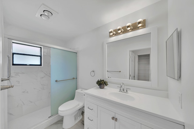 bathroom with a tile shower, vanity, and toilet