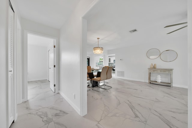 unfurnished office featuring ceiling fan with notable chandelier