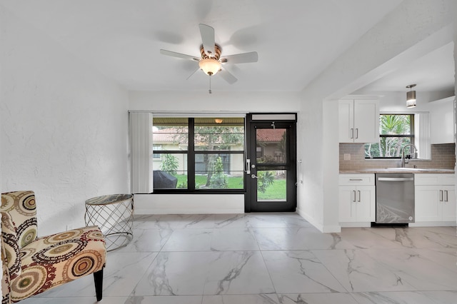 kitchen featuring ceiling fan, sink, dishwasher, backsplash, and white cabinetry