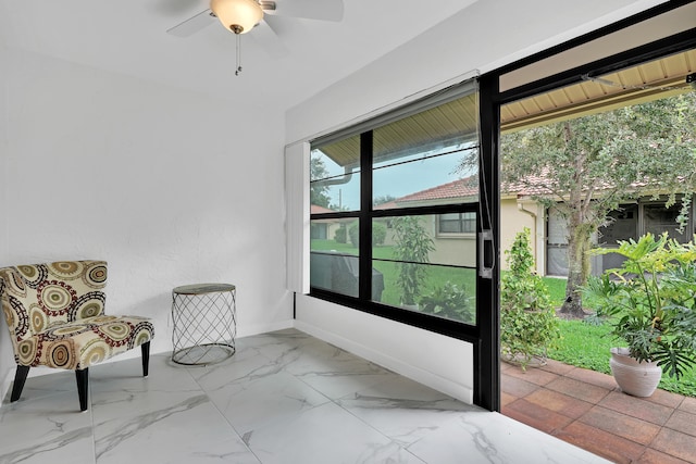 unfurnished sunroom featuring ceiling fan