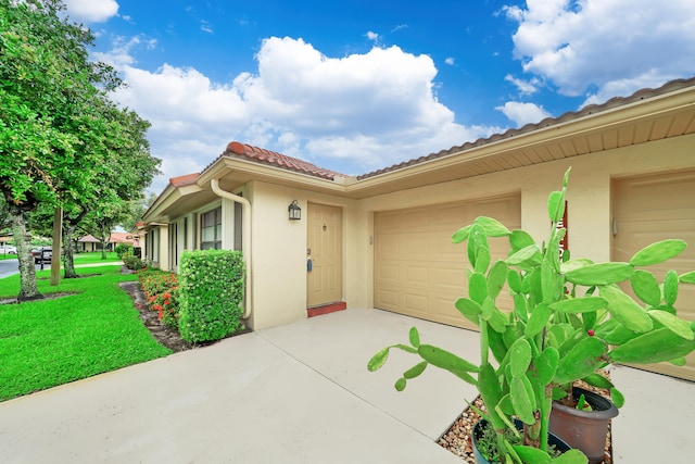 property entrance featuring a garage and a yard