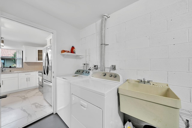 laundry room featuring washing machine and clothes dryer and sink