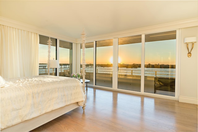 bedroom with wood-type flooring, access to exterior, ornamental molding, and expansive windows