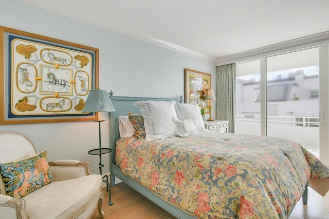 bedroom with ornamental molding and light wood-type flooring