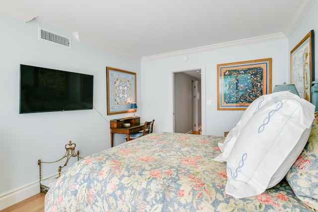 bedroom with ornamental molding and hardwood / wood-style flooring