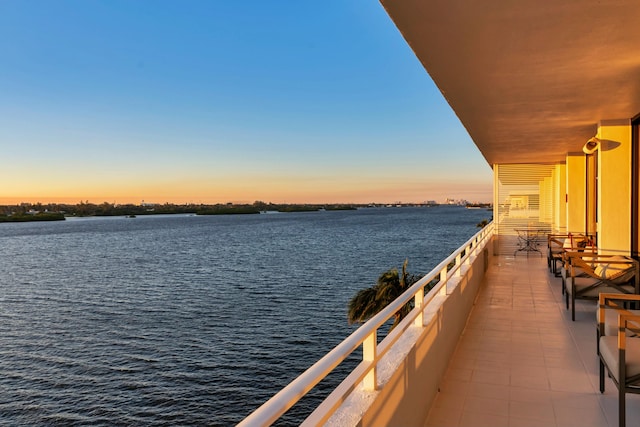 dock area with a balcony and a water view