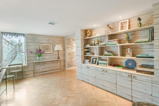 interior space with light parquet flooring and wood walls