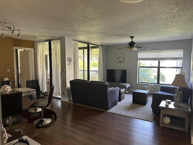 living area featuring ceiling fan, wood finished floors, a textured ceiling, and plenty of natural light