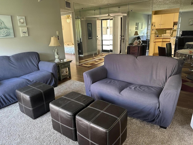 living area with wood finished floors and a textured ceiling