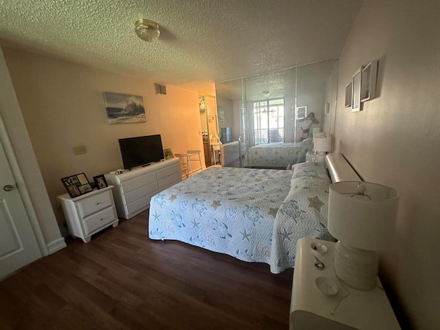 bedroom with dark hardwood / wood-style flooring and a textured ceiling