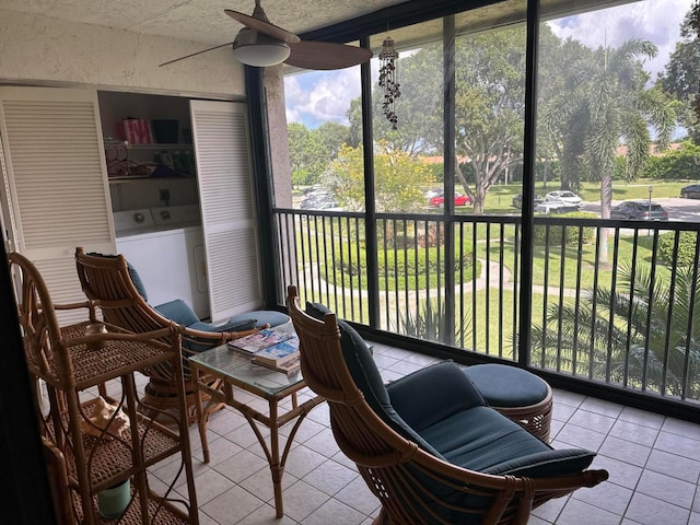 sunroom with ceiling fan and separate washer and dryer