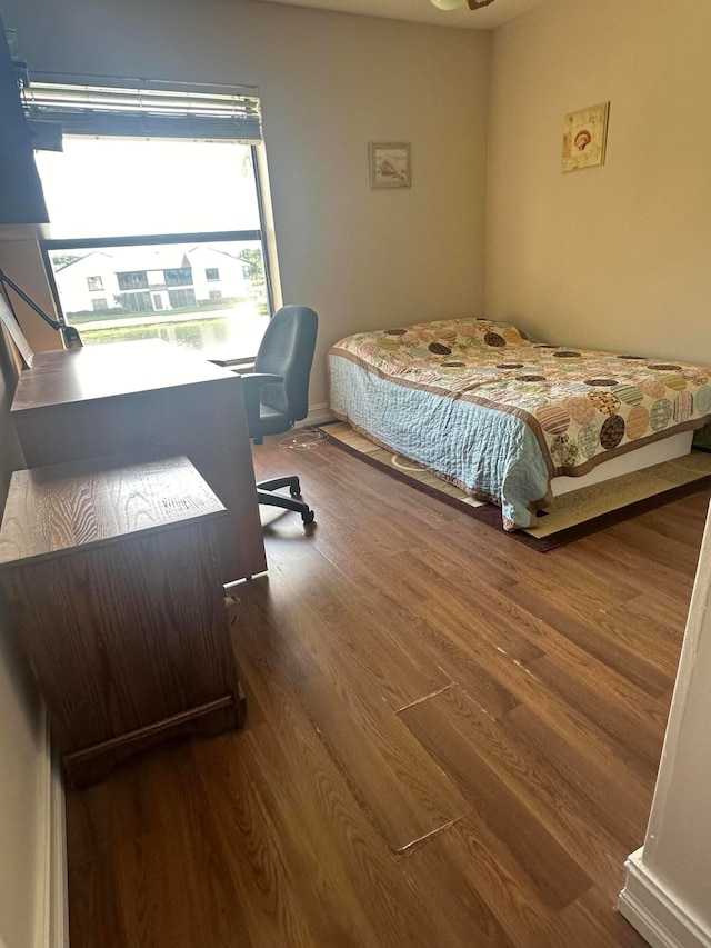 bedroom with dark hardwood / wood-style floors