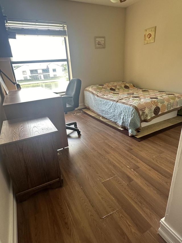 bedroom featuring wood finished floors and a desk