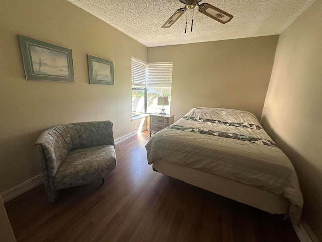 bedroom with dark wood-type flooring, a textured ceiling, and ceiling fan