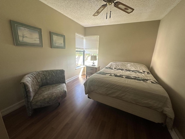 bedroom featuring wood finished floors, a textured ceiling, ceiling fan, and baseboards
