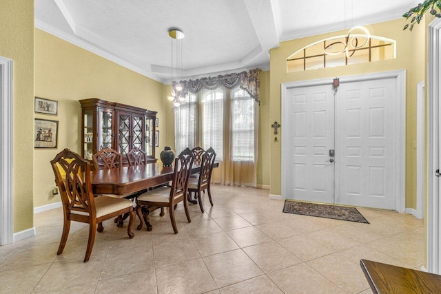 dining room featuring a textured ceiling, crown molding, and light tile patterned flooring