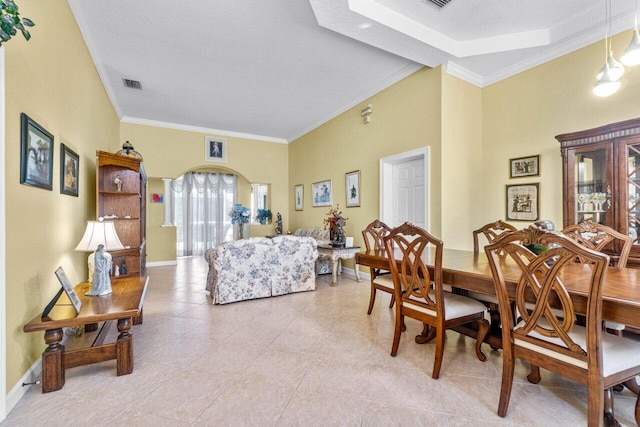 tiled dining space with a textured ceiling and ornamental molding