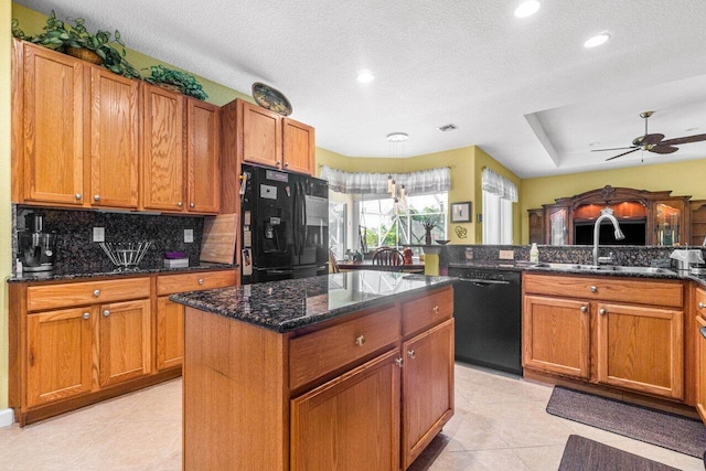 kitchen with dark stone counters, black appliances, a textured ceiling, and sink