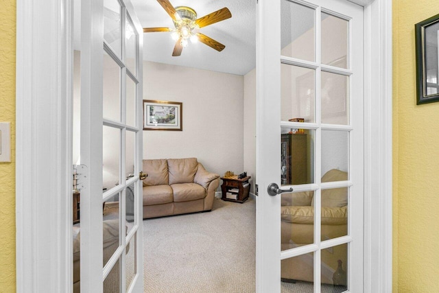 interior space featuring a textured ceiling, carpet, ceiling fan, and french doors