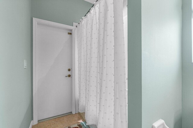 bathroom featuring walk in shower and tile patterned floors