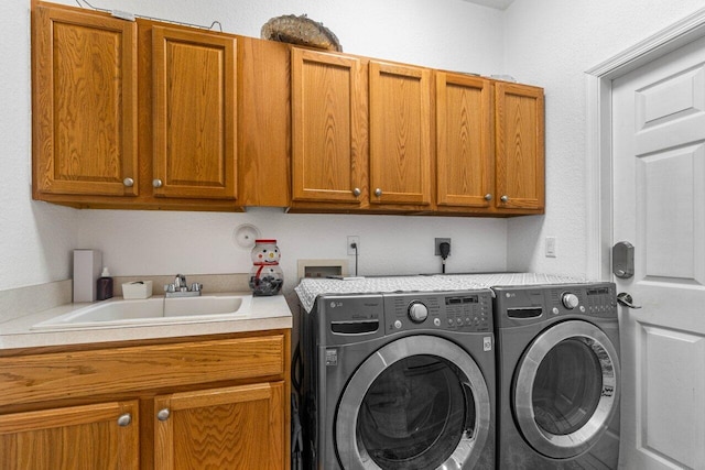 laundry area featuring cabinets, washer and clothes dryer, and sink