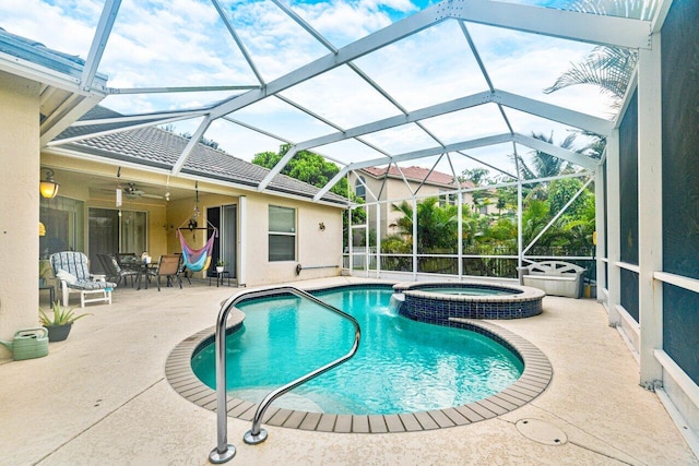 view of pool with a lanai, an in ground hot tub, and a patio area