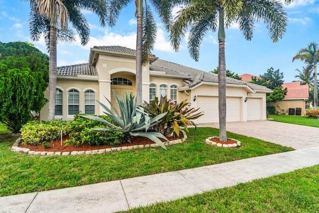 mediterranean / spanish-style home featuring a garage and a front lawn