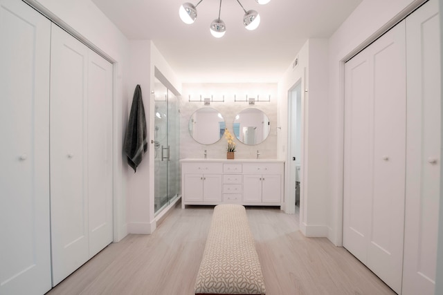 bathroom with vanity, a shower with shower door, and hardwood / wood-style flooring