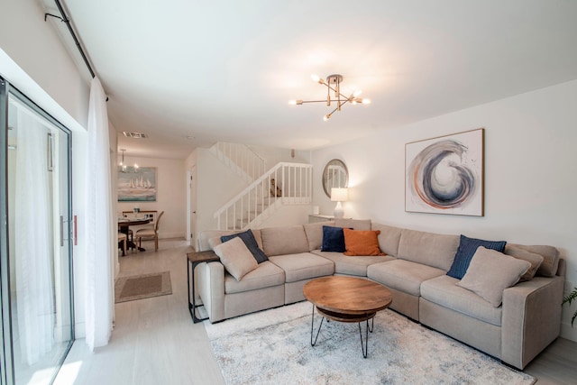 living room featuring light wood-type flooring and a chandelier