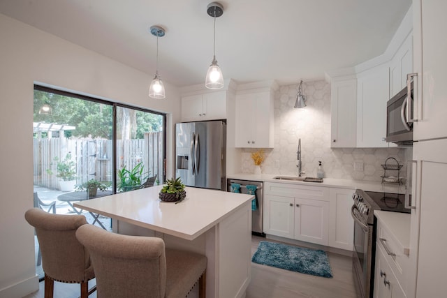 kitchen with white cabinets, sink, light hardwood / wood-style flooring, backsplash, and stainless steel appliances