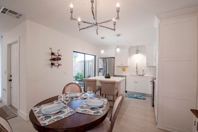 dining room featuring light wood-type flooring and sink