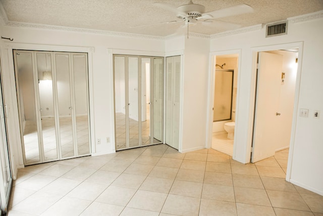 unfurnished bedroom with ensuite bath, a textured ceiling, and ceiling fan