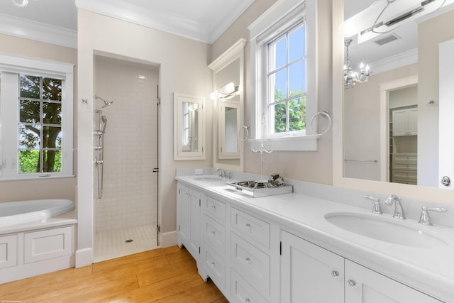 bathroom featuring separate shower and tub, vanity, hardwood / wood-style flooring, ornamental molding, and an inviting chandelier