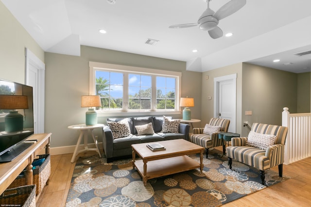 living room featuring vaulted ceiling, light wood-type flooring, and ceiling fan