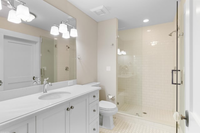 bathroom with vanity, toilet, a shower with shower door, and tile patterned flooring