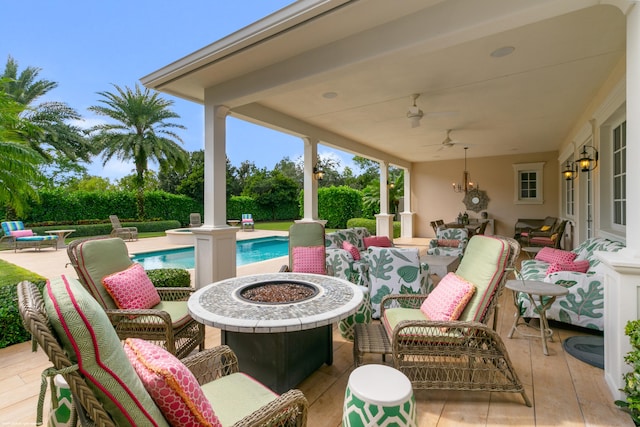 view of patio / terrace featuring a fenced in pool, an outdoor living space with a fire pit, and ceiling fan