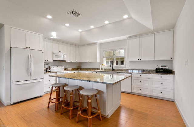 kitchen with a center island, light hardwood / wood-style floors, white cabinetry, and white appliances