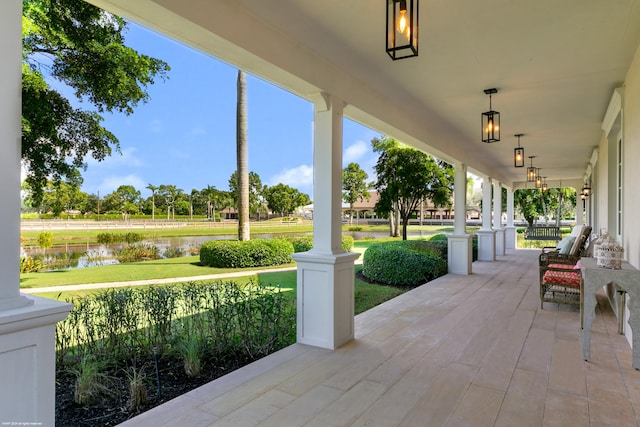 view of patio with a water view and a porch